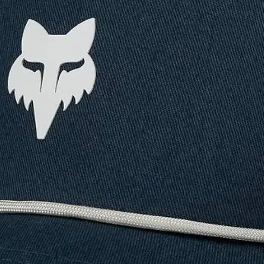 Detalle real del logo Fox Head en gorra azul marino